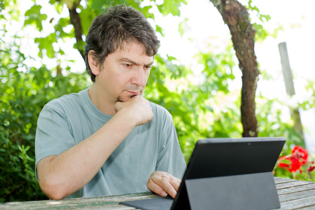 casual man working with a tablet pc, outdoorの写真素材