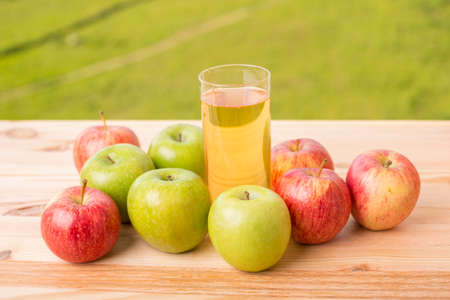 apples and apple juice on a wooden table, outdoorの写真素材