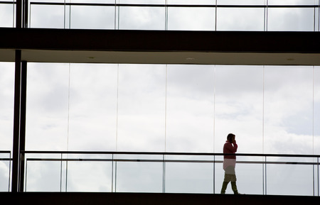 Silhouette view of young businessman in a modern office building interior with panoramic windows.の写真素材