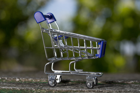 small shopping cart, studio picture on a wooden tableの写真素材