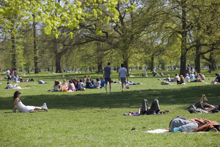 Large amounts of people relaxing at the park during the afternoon in Londonのeditorial素材
