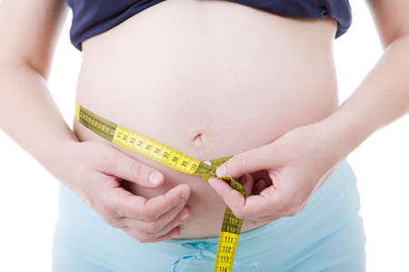Fat young woman tied measure tape on her bellyの写真素材