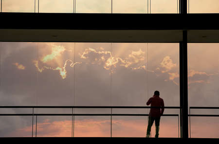 Silhouette view of young businessman in a modern office building interior with panoramic windows.の写真素材