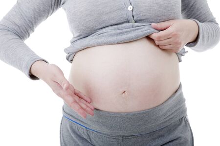 Closeup of pregnant woman at white backgroundの写真素材