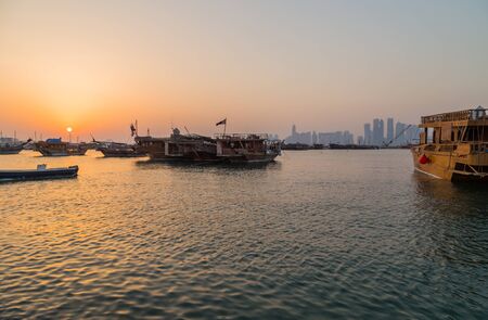 Traditional boats called Dhows are anchored in the port near Museum of Islamic, in Doha, Qatar.のeditorial素材