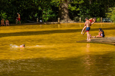 Furnas, Azores, Portugal - August 16, 2020: People swimming in a mineral thermal pool in the Terra Nostra botanical garden at Furnas, Sao Miguel island, Azores. The spring supplies the pool at a temperature of 35-40 degrees Celsiusのeditorial素材