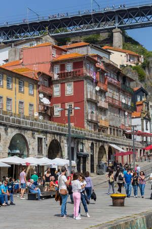 PORTO, PORTUGAL: Tourists and locals enjoy the Ribeira in the Douro River bank near the Dom Luis I Bridge, Porto, Portugal.のeditorial素材