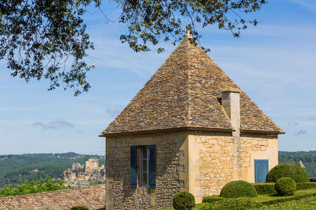 Topiary in the gardens of the Jardins de Marqueyssac in the Dordogne region of France. Castle of Castelnaud on the back.のeditorial素材