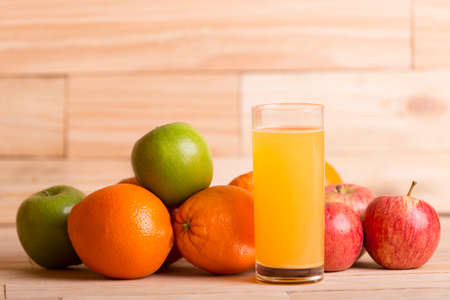variety of fruits and orange juice on a wooden table, studio picture