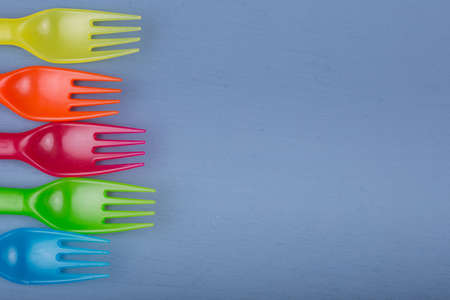 Kids forks. Composition of Colorful forks on a blue wooden table