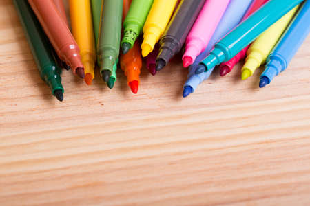 Colorful markers pens on a wooden tableの写真素材