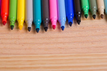 Colorful markers pens on a wooden tableの写真素材