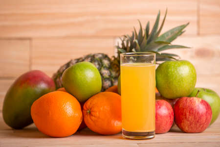 variety of fruits and orange juice on a wooden table, studio pictureの写真素材