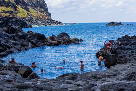 Ponta da Ferraria, Azores, Portugal: People bathing in natural volcanic thermal pool in Ponta da Ferraria, the place where hot springs mix with seawater.のeditorial素材