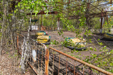 Old broken rusty metal radioactive children's electric cars  abandoned, the park of culture and recreation in the city of Pripyat, the Chernobyl disaster, Ukraine.の写真素材