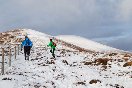 CO KERRY, IRLAND: People climbing in the snow at the Paps of Anu, Co Kerry, Irelandのeditorial素材