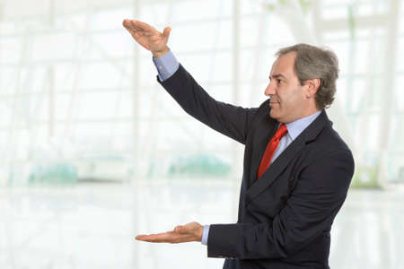 friendly mature businessman presenting something at the office