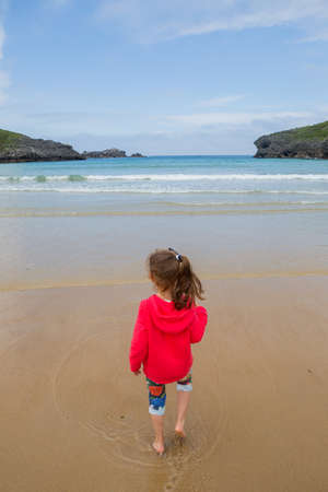 Cute little girl playing at the beach, in the north of Spainの写真素材