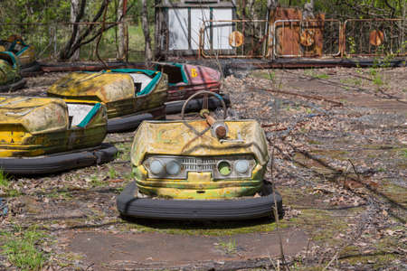 Old broken rusty metal radioactive children's electric cars  abandoned, the park of culture and recreation in the city of Pripyat, the Chernobyl disaster, Ukraine.の写真素材
