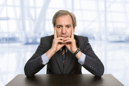 mature business man on a desk, at the officeの写真素材