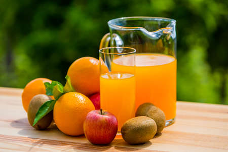 orange juice and fruits on a table, outdoorの写真素材