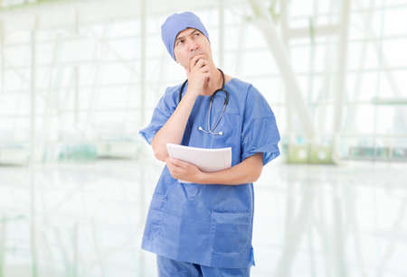 doctor thinking with his notes at the hospitalの写真素材