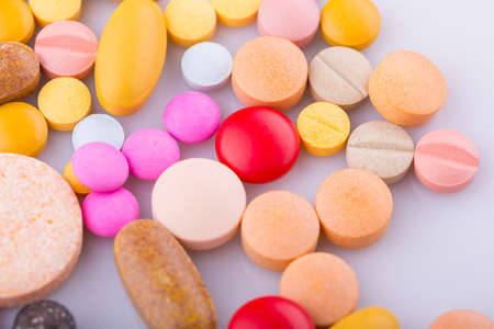 Tablets pills capsule heap mix therapy drugs, over a white backgroundの写真素材