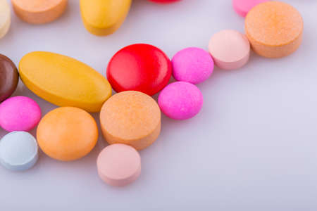 Tablets pills capsule heap mix therapy drugs, over a white backgroundの写真素材