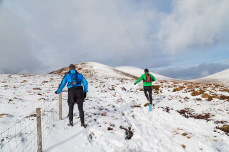 CO KERRY, IRLAND: People climbing in the snow at the Paps of Anu, Co Kerry, Irelandのeditorial素材
