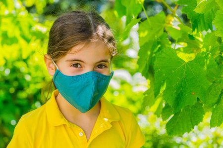 Little girl with mask against  virus  outdoorの写真素材