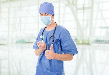 Happy male doctor showing thumbs up, at the hospitalの写真素材