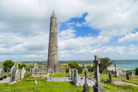 Stone round tower and some ruins of a monastic settlement originally built in the 6th century in Glendalough valley, County Wicklow, Ireland.のeditorial素材