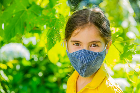 Little girl with mask outdoorの写真素材