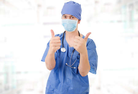 Happy male doctor showing thumbs up, at the hospitalの写真素材