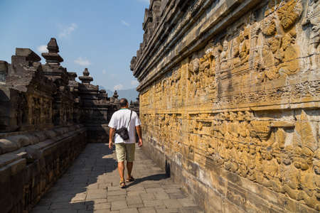 Man walking in the ancient Buddhist temple of Borobudur, in Magelang, Central Java, Indonesiaの写真素材