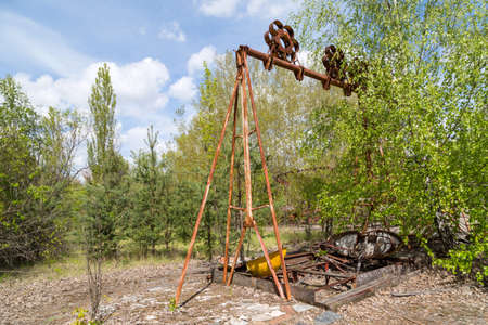 Old broken rusty metal radioactive children's electric wheel abandoned, the park of culture and recreation in the city of Pripyat, the Chernobyl disaster, Ukraine.の写真素材