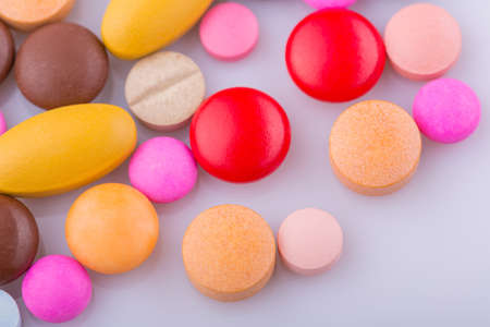 Tablets pills capsule heap mix therapy drugs, over a white backgroundの写真素材