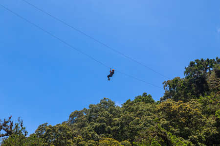Monteverde, Costa Rica: young adventurous woman zip lining thru the forest. Monteverde, Costa Rica.のeditorial素材