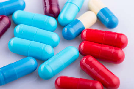 Tablets pills capsule heap mix therapy drugs, over a white backgroundの写真素材