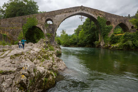 Cangas de Onis, Spain: People at the Roman bridge built in the late 13th century over the Sella River in Cangas de Onis, Asturias, Spain.のeditorial素材