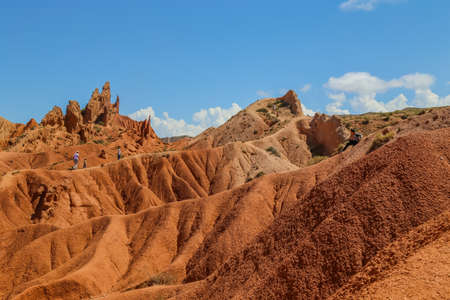 Issyk-Kul, Kyrgyzstan: People on the red sandstone rock formations Seven bulls and Broken heart, Jeti Oguz canyon in Kyrgyzstan, Issyk-Kul region, Central Asiaのeditorial素材