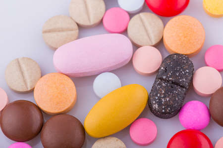Tablets pills capsule heap mix therapy drugs, over a white backgroundの写真素材
