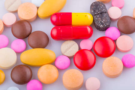 Tablets pills capsule heap mix therapy drugs, over a white backgroundの写真素材