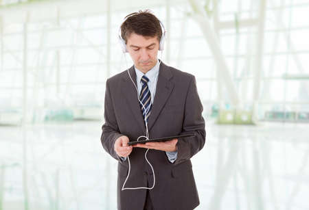businessman with tablet pc and headphones, at the officeの写真素材