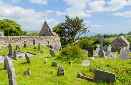 Stone round tower and some ruins of a monastic settlement originally built in the 6th century in Glendalough valley, County Wicklow, Ireland.のeditorial素材
