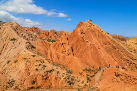 Issyk-Kul, Kyrgyzstan: People on the red sandstone rock formations Seven bulls and Broken heart, Jeti Oguz canyon in Kyrgyzstan, Issyk-Kul region, Central Asiaのeditorial素材