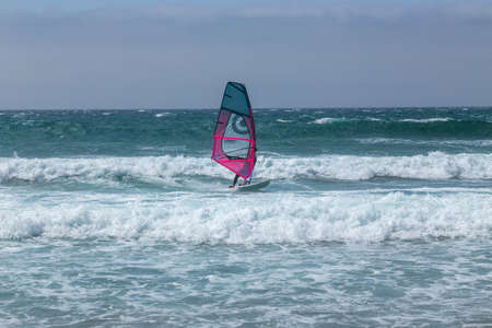 summer sports: a surfer riding the wave during a sunny day on the blue ocean sea of Guincho, Portugal.のeditorial素材