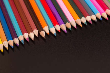 Wooden colorful pencils, on a dark background