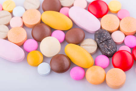 Tablets pills capsule heap mix therapy drugs, over a white backgroundの写真素材