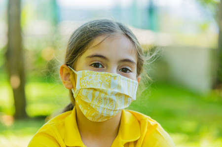Little girl with mask against corona virus covid outdoorの写真素材